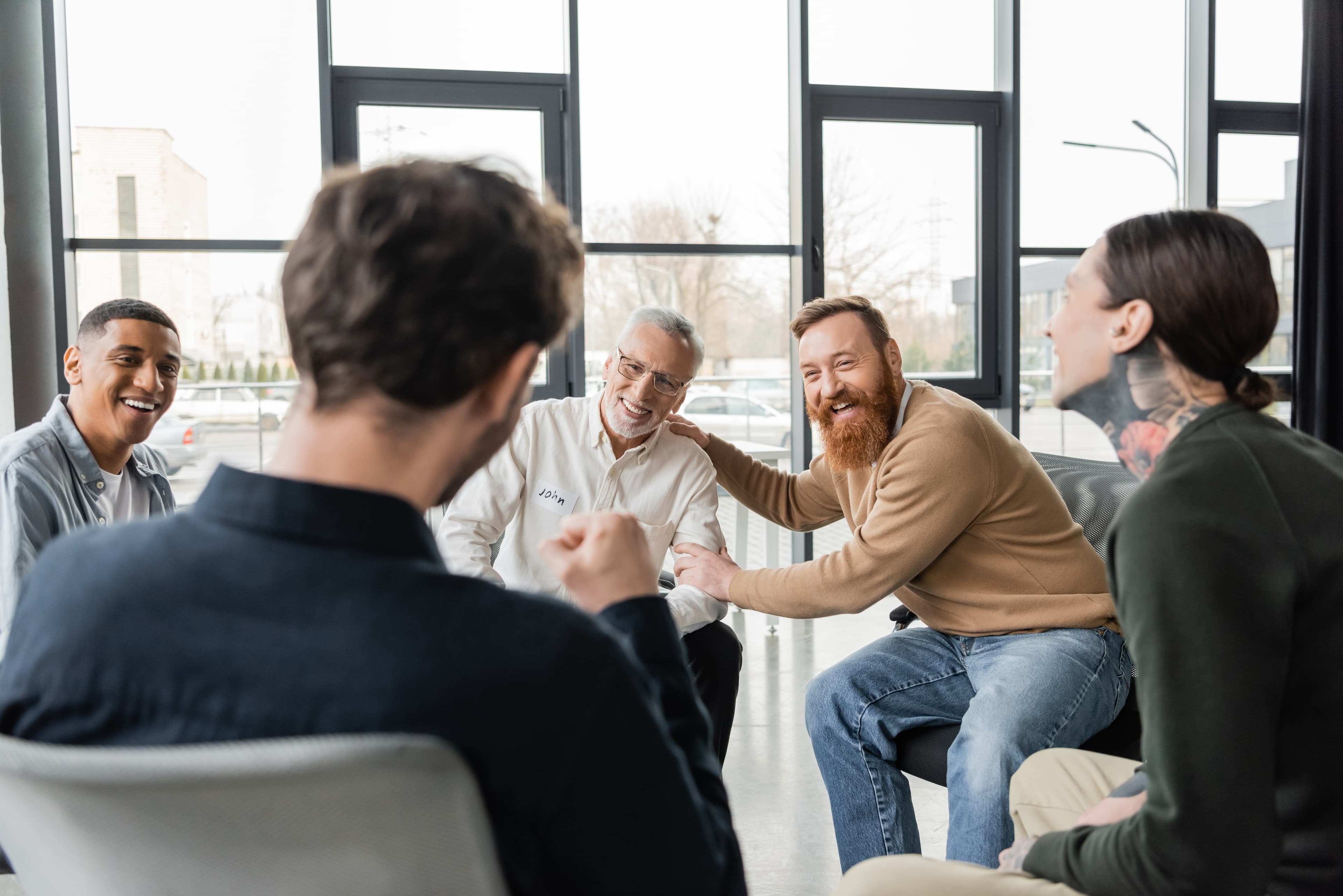 A group meeting where a room of people offer support to each other in order to combat their issues with AUD and alcoholism.