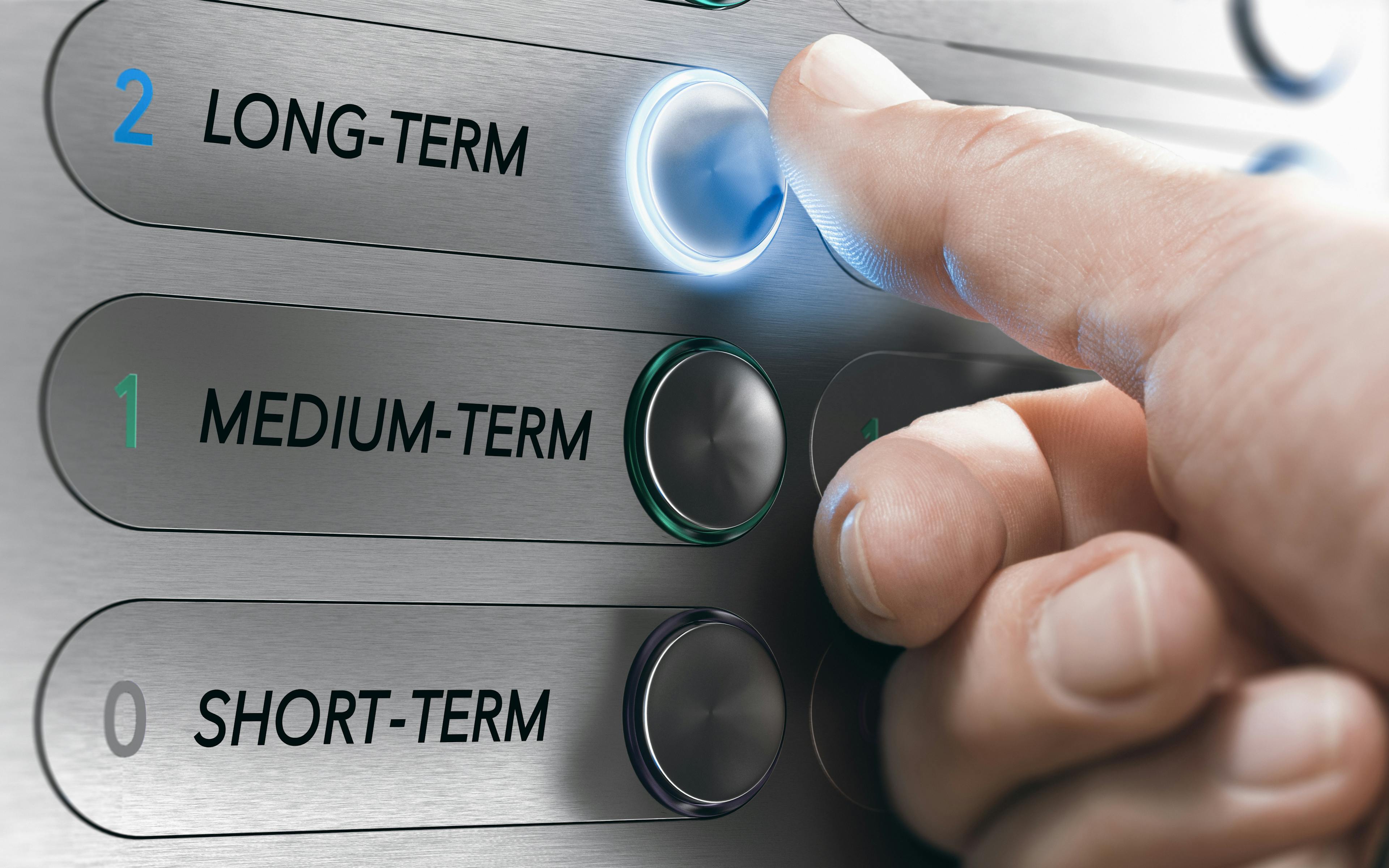 A hand pressing the button for the "long term" in an elevator