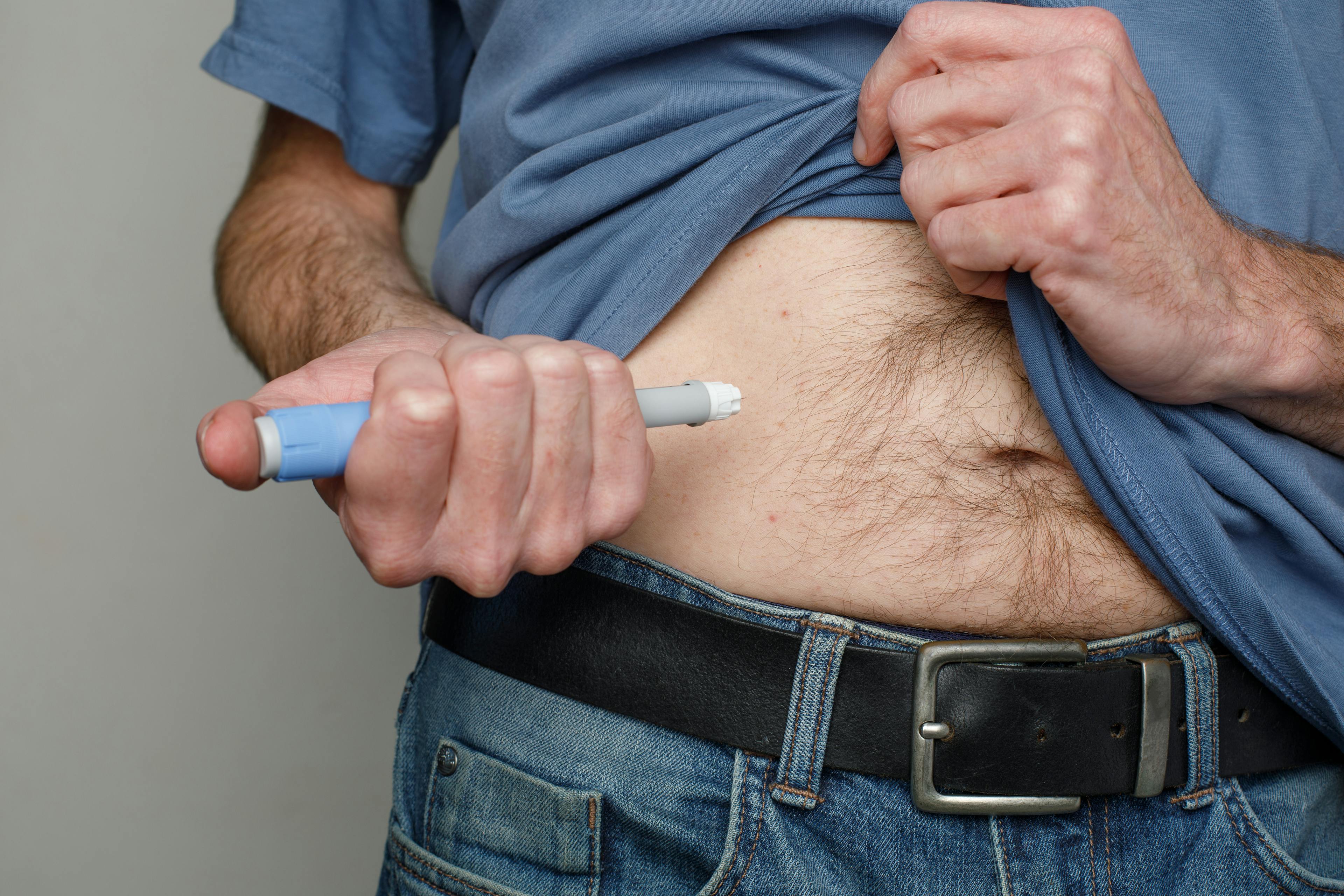 A man injecting himself in the belly with Ozempic